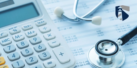 Stethoscope and calculator on top of medical bills